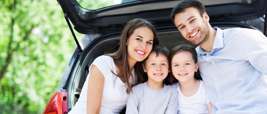 Ratgeber Autofahren mit Kind – Vierköpfige Familie sitzt im Kofferraum eines Autos
